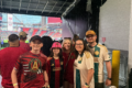 A picture of Will and his family posing for a photograph near the soccer field.