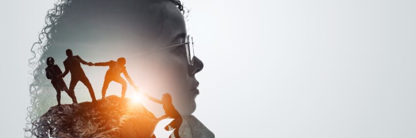 Silhouette of a leader’s profile blended with a team climbing a mountain, symbolizing clarity, support, and strong leadership mindset.