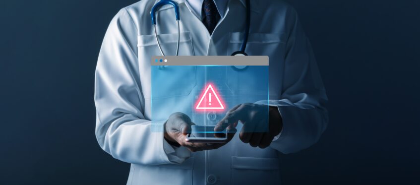 Healthcare professional holding a tablet displaying a digital warning alert, representing operational risk and HIPAA compliance challenges in healthcare workflows.